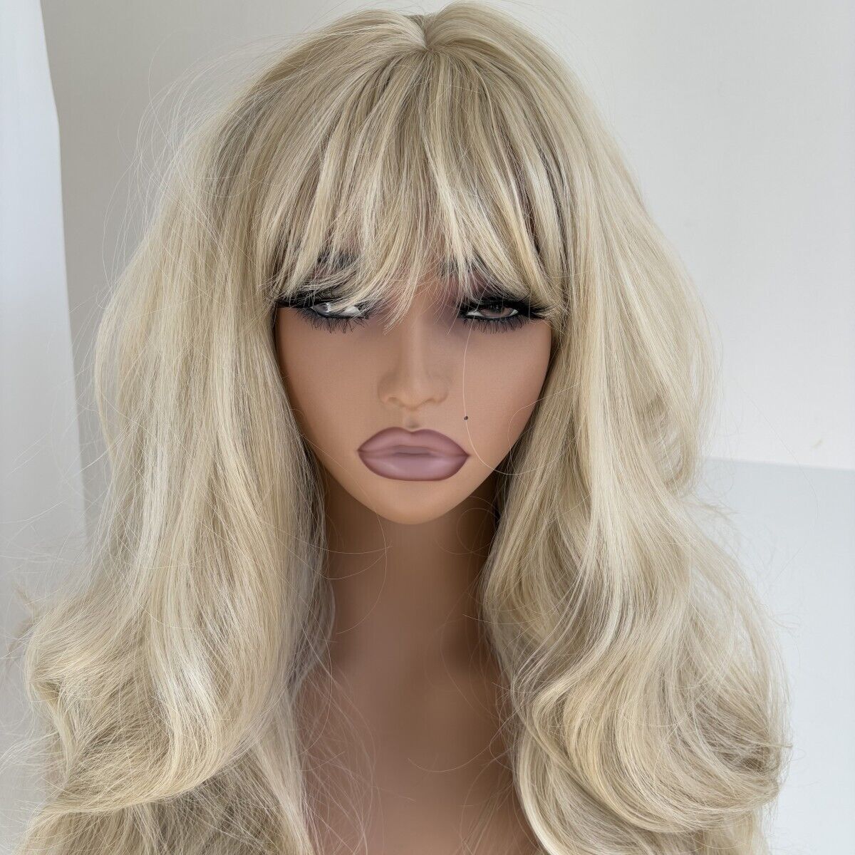 Long wow hair and bangs of long wavy gray blonde hair